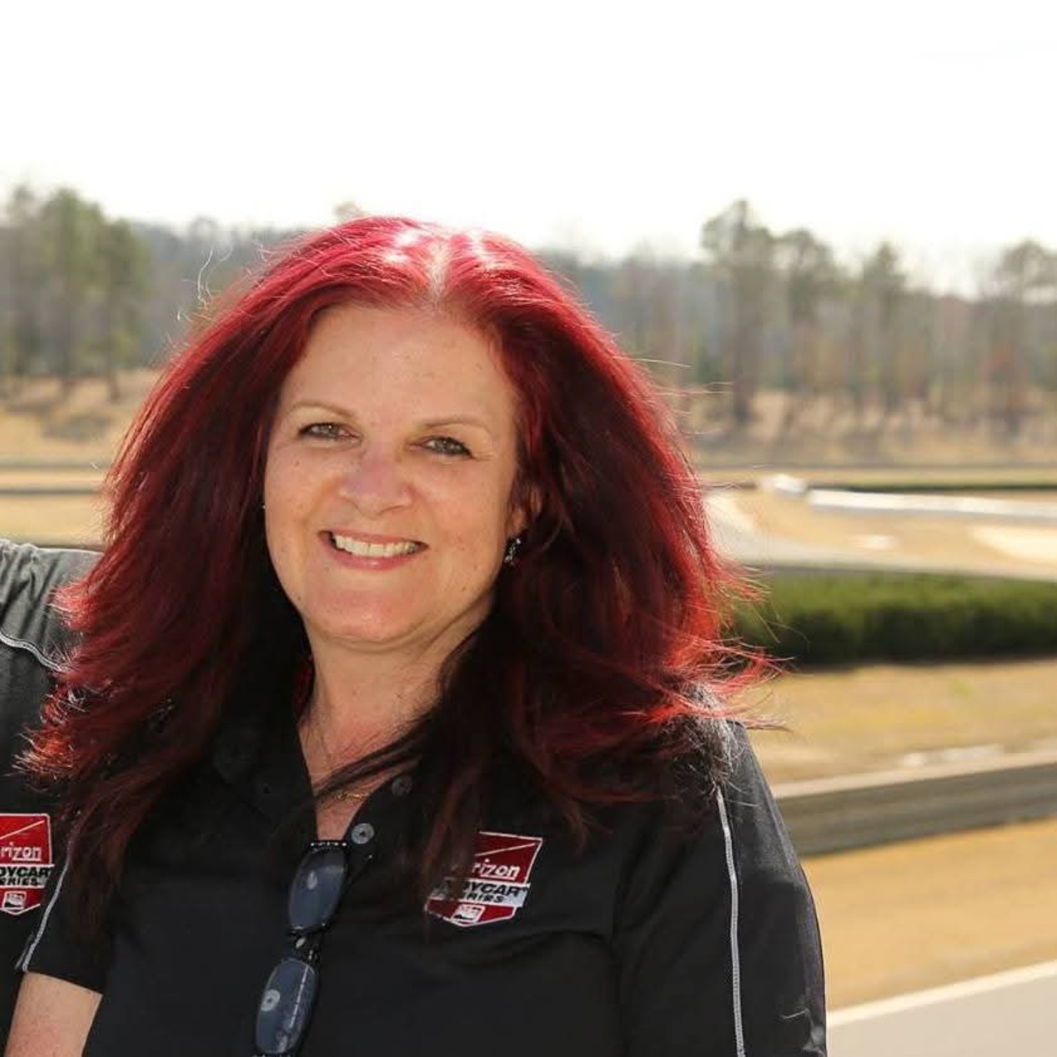 Kathi smiling at a racetrack